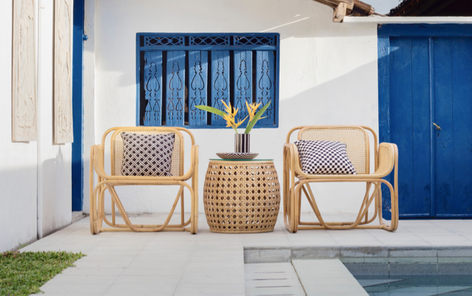 An outdoor rattan chair set and center table beside a pool.